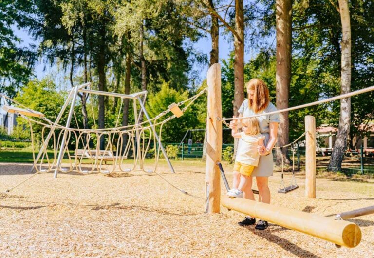 Mutter hilft Kind über den Wackelbalken